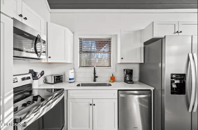 kitchen featuring white cabinets, stainless steel appliances, and sink