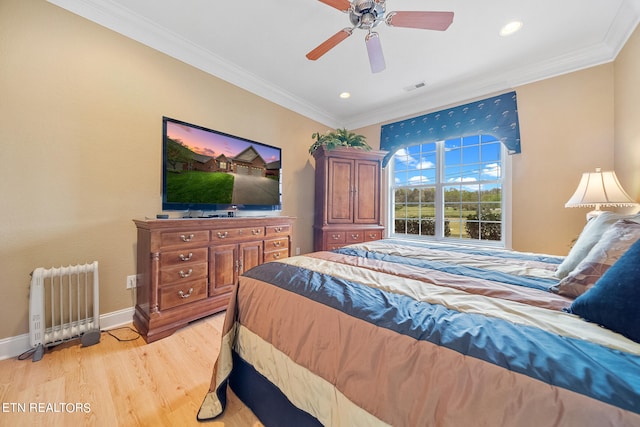 bedroom featuring crown molding, light hardwood / wood-style floors, radiator heating unit, and ceiling fan