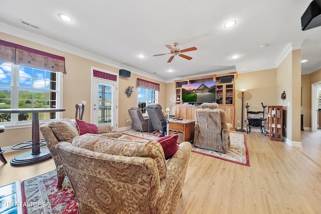 living room with crown molding, light hardwood / wood-style flooring, and ceiling fan