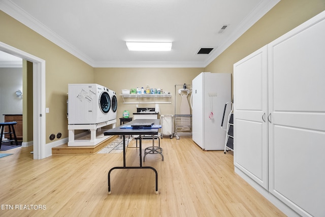 kitchen featuring white refrigerator, independent washer and dryer, light wood-type flooring, and ornamental molding