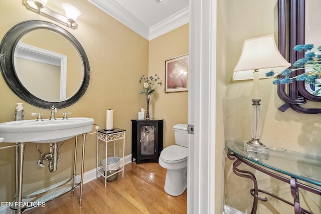 bathroom with hardwood / wood-style floors, ornamental molding, and toilet