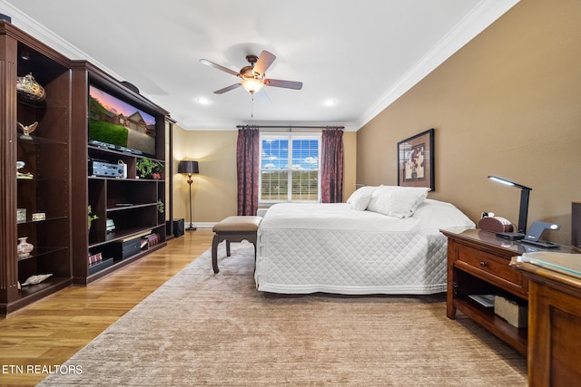 bedroom with crown molding, light hardwood / wood-style floors, and ceiling fan