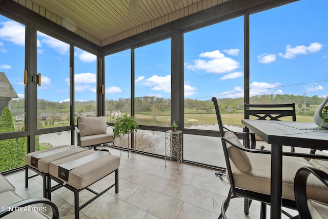 sunroom featuring wood ceiling, a healthy amount of sunlight, and a water view