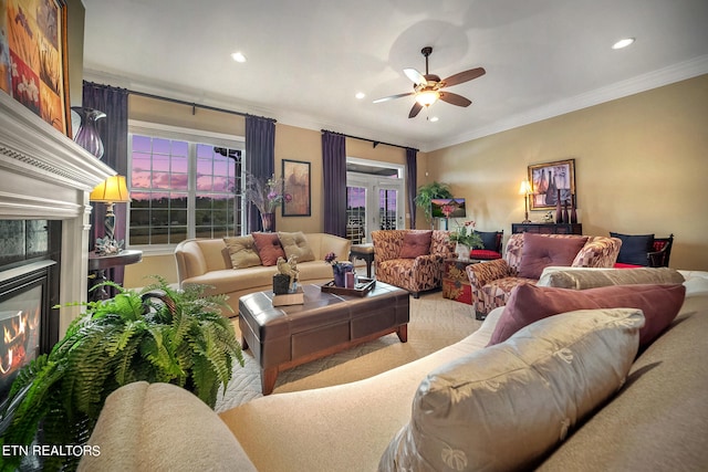 living room with french doors, ceiling fan, crown molding, and a tile fireplace