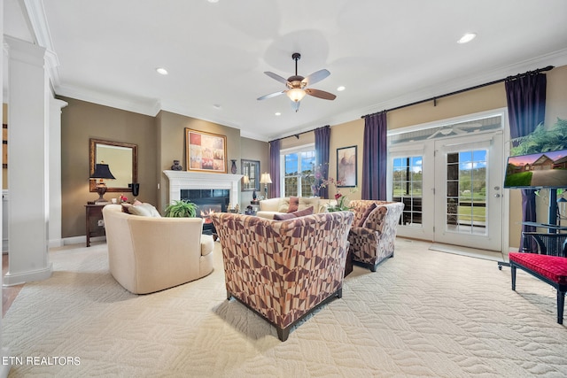 carpeted living room featuring ornamental molding, a tiled fireplace, and ceiling fan