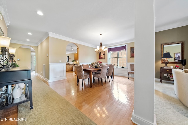 dining area featuring an inviting chandelier, crown molding, and light wood-type flooring