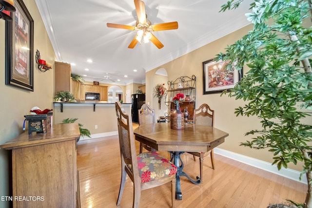 dining area featuring ornamental molding and light hardwood / wood-style floors