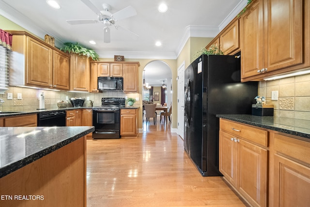 kitchen featuring backsplash, light hardwood / wood-style flooring, ceiling fan, and black appliances