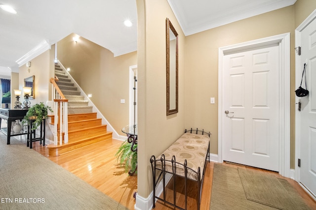 entrance foyer featuring ornamental molding and light hardwood / wood-style floors