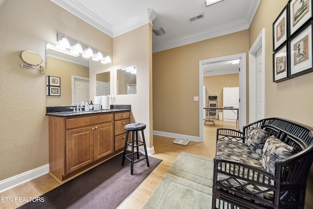 interior space featuring oversized vanity, hardwood / wood-style floors, and ornamental molding