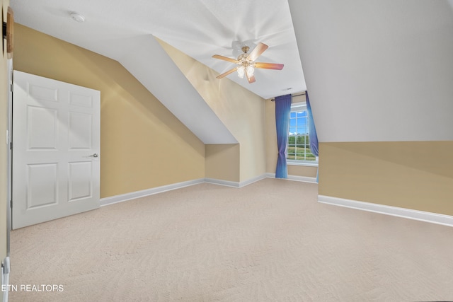 additional living space featuring light colored carpet, ceiling fan, and vaulted ceiling