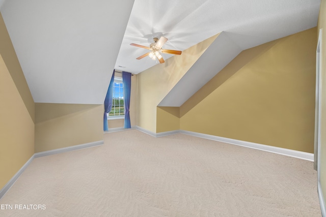 bonus room with light colored carpet, lofted ceiling, and ceiling fan