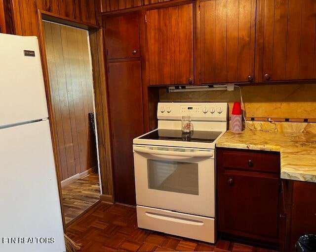 kitchen with dark parquet floors and white appliances