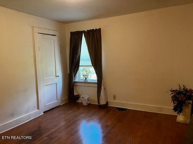 empty room with dark wood-type flooring