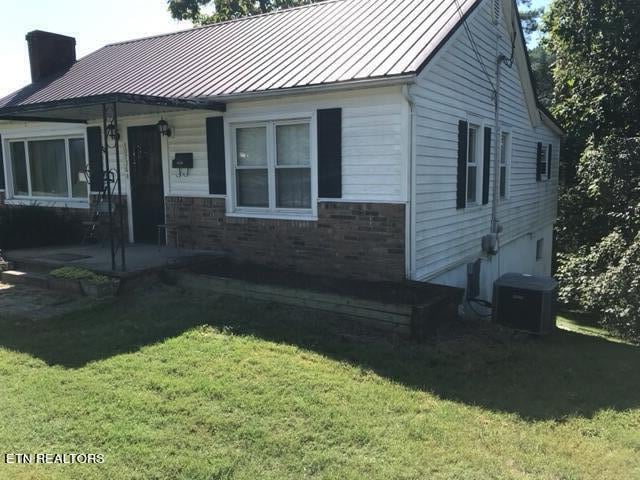 view of front of house featuring central air condition unit and a front yard