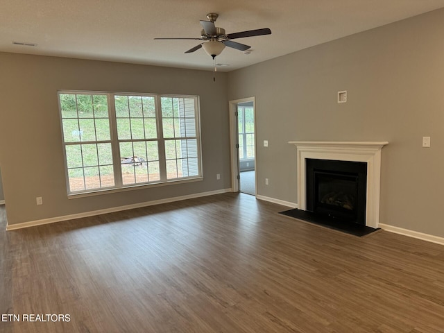 unfurnished living room featuring ceiling fan and dark wood-type flooring