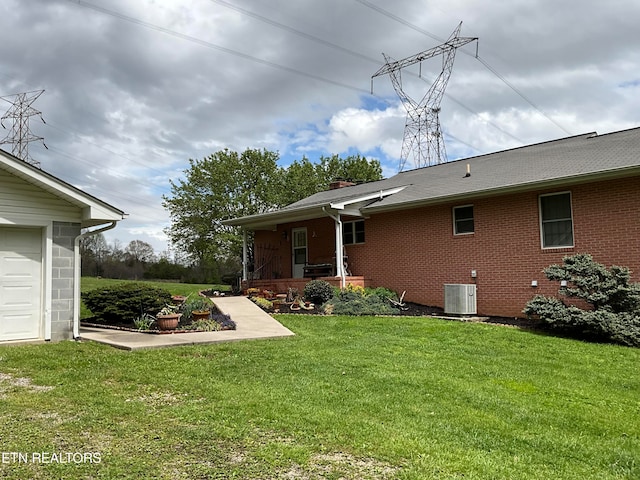 view of yard with a garage and central AC