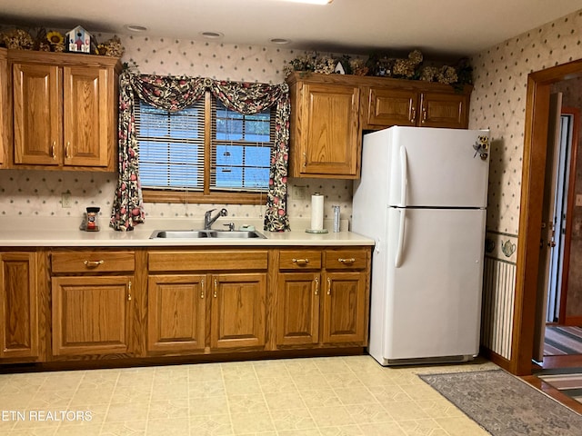 kitchen with white fridge, sink, and light tile floors