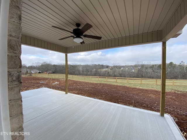 view of patio / terrace with ceiling fan and a rural view