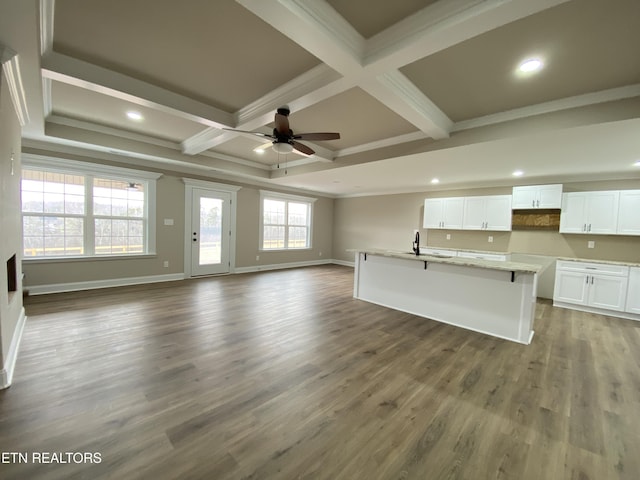 kitchen with hardwood / wood-style floors, coffered ceiling, beamed ceiling, ceiling fan, and white cabinets