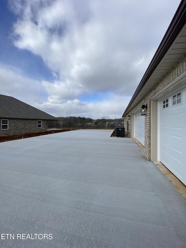 view of yard with central AC unit and a garage