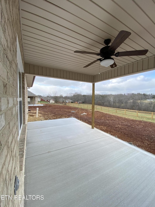 view of patio / terrace with ceiling fan and a rural view