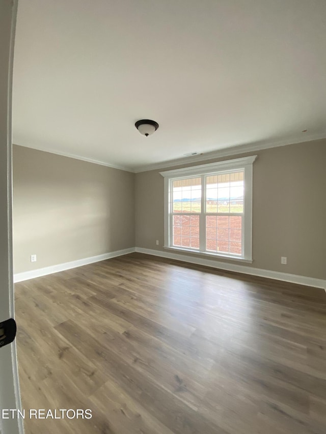 unfurnished room featuring hardwood / wood-style floors and crown molding