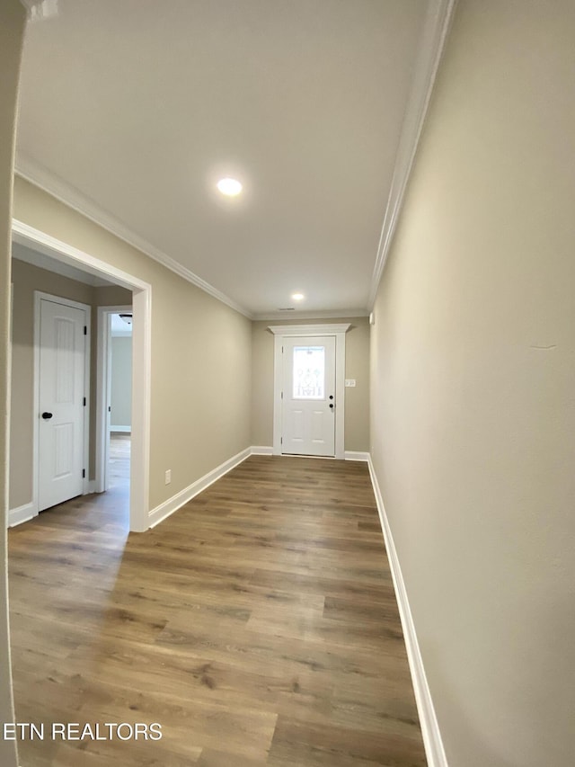 interior space with ornamental molding and wood-type flooring