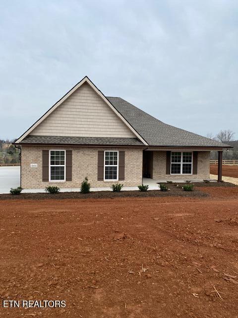 ranch-style home featuring brick siding and a shingled roof