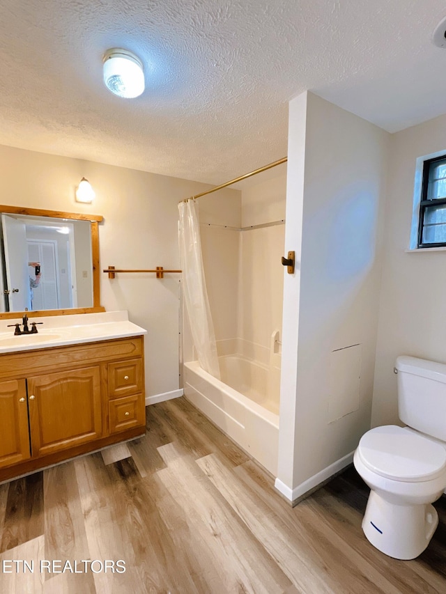 full bathroom featuring vanity, toilet, wood-type flooring, and a textured ceiling