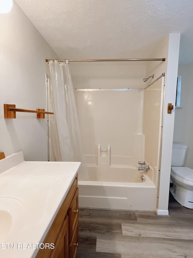 full bathroom with shower / bath combination with curtain, a textured ceiling, toilet, vanity, and hardwood / wood-style flooring