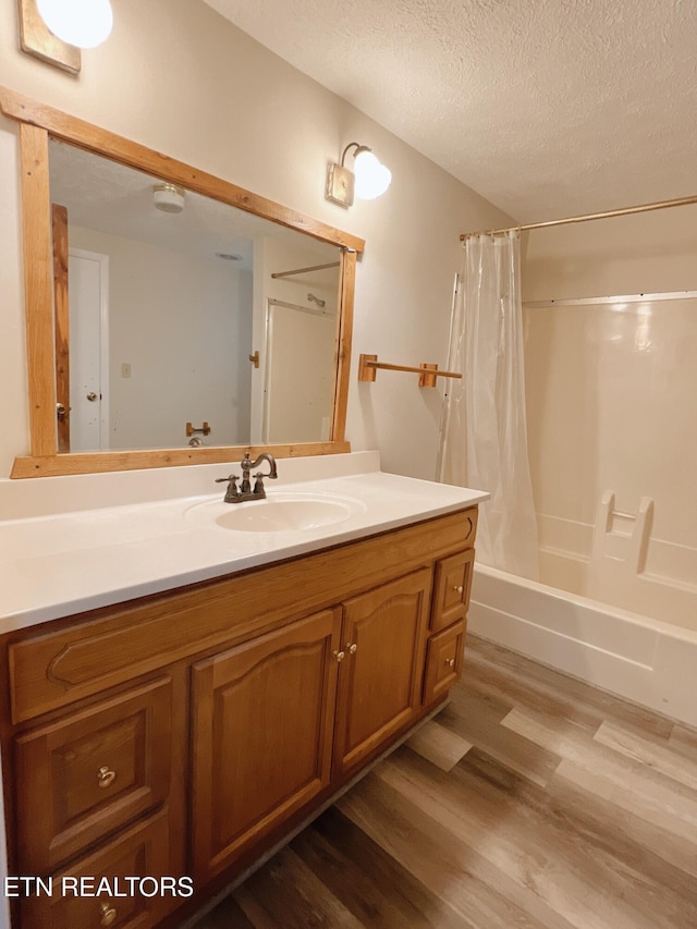 555 Lake Ln, New Tazewell, TN 37825 - bathroom with vanity, wood finished floors, a textured ceiling, and shower / bathtub combination with curtain
