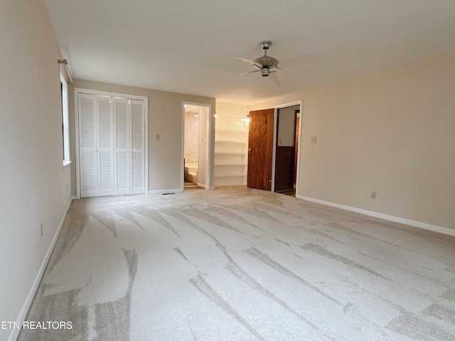 unfurnished bedroom with light carpet, ensuite bath, and ceiling fan