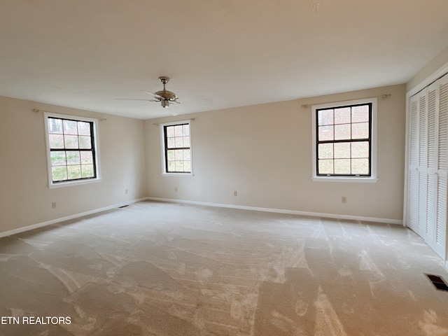 empty room featuring light colored carpet and ceiling fan