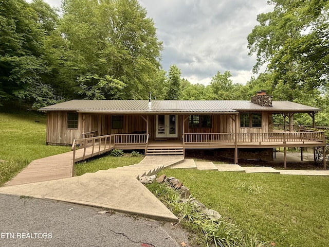 555 Lake Ln, New Tazewell, TN 37825 - view of front of house featuring covered porch, a front lawn, board and batten siding, a chimney, and a metal roof