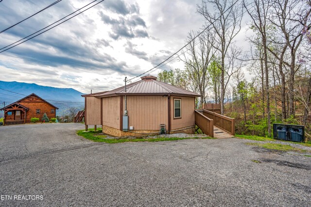 view of front of property featuring a mountain view and an outdoor structure