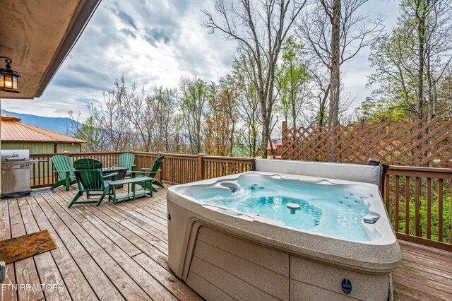 wooden terrace featuring a hot tub and area for grilling