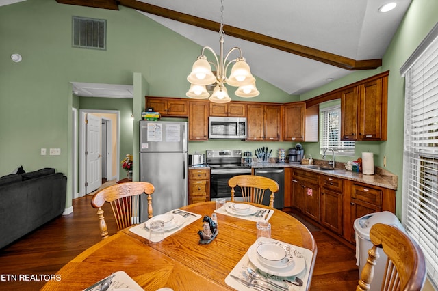 kitchen with beamed ceiling, appliances with stainless steel finishes, dark wood-type flooring, a chandelier, and pendant lighting