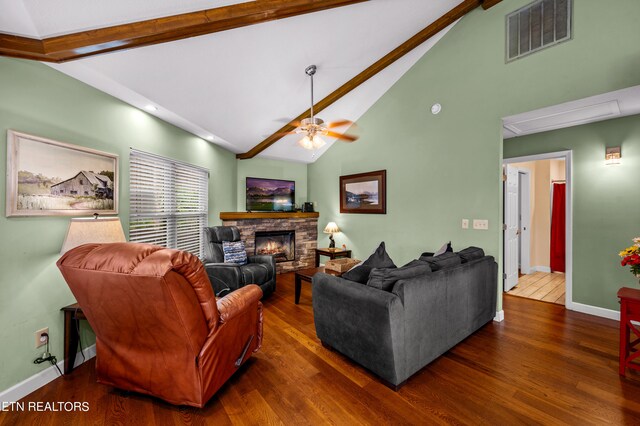 living room featuring lofted ceiling with beams, dark hardwood / wood-style flooring, ceiling fan, and a fireplace