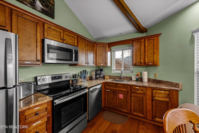 kitchen with light stone counters, sink, dark wood-type flooring, lofted ceiling, and stainless steel appliances