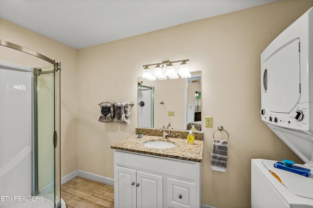 bathroom with walk in shower, toilet, vanity with extensive cabinet space, stacked washer / drying machine, and tile flooring