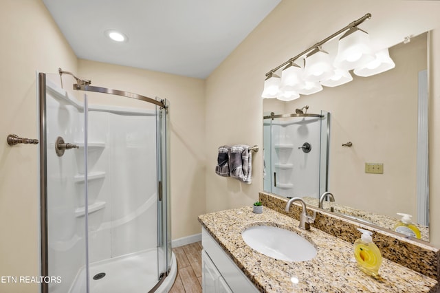 bathroom featuring walk in shower, vanity, and hardwood / wood-style flooring