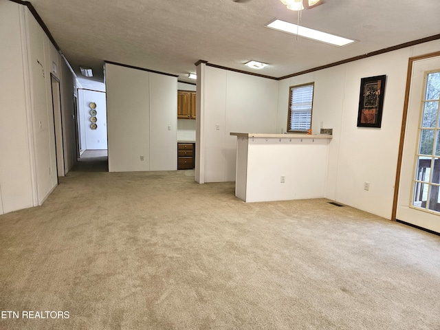 carpeted spare room featuring a textured ceiling and ornamental molding