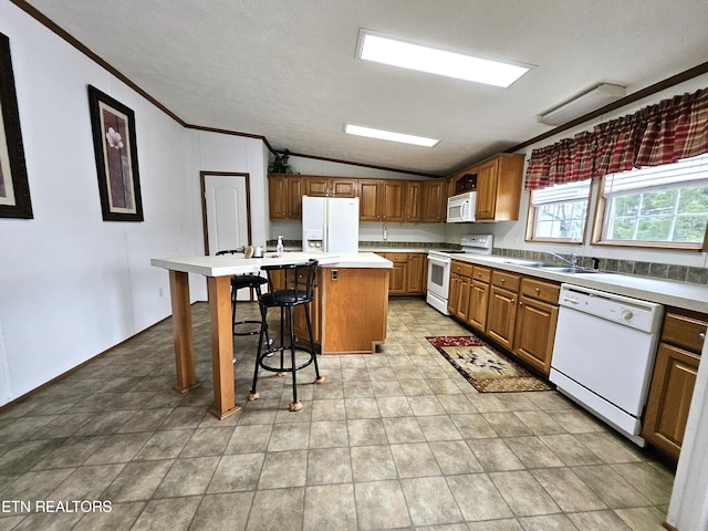 kitchen with white appliances, light tile floors, a kitchen island, and a breakfast bar area