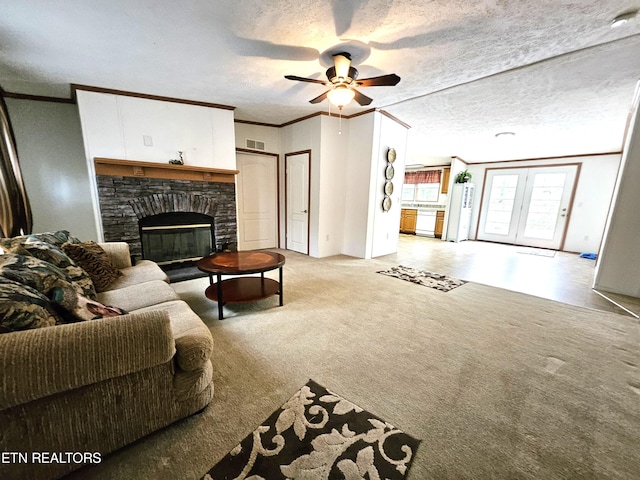 living room with light colored carpet, a stone fireplace, ceiling fan, a textured ceiling, and ornamental molding