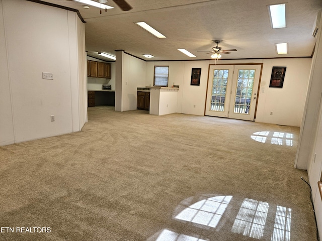 spare room with light colored carpet, ceiling fan, ornamental molding, and a textured ceiling