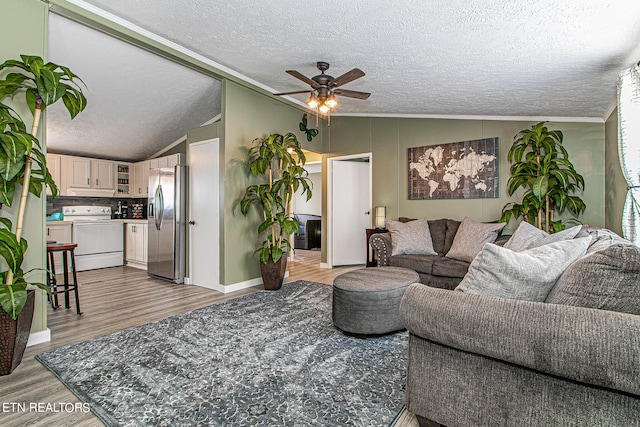 living room featuring light hardwood / wood-style flooring, ceiling fan, a textured ceiling, and lofted ceiling