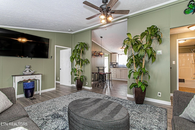 living room with crown molding, dark hardwood / wood-style floors, ceiling fan, a textured ceiling, and lofted ceiling