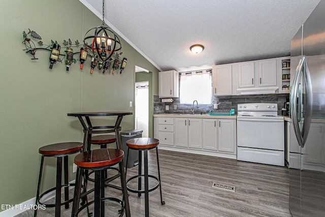 kitchen featuring electric stove, white cabinets, hanging light fixtures, dark hardwood / wood-style flooring, and vaulted ceiling