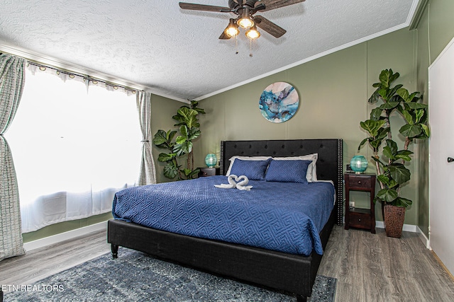 bedroom with ornamental molding, a textured ceiling, ceiling fan, and hardwood / wood-style floors